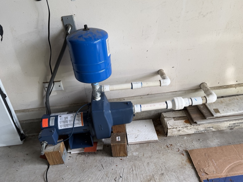 Well pump and pressure tank installed in a garage