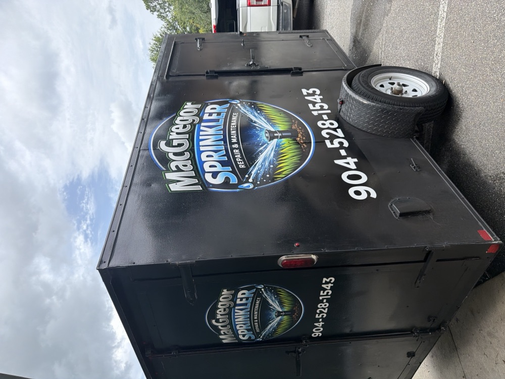MacGregor Sprinkler enclosed trailer with the company logo and phone number